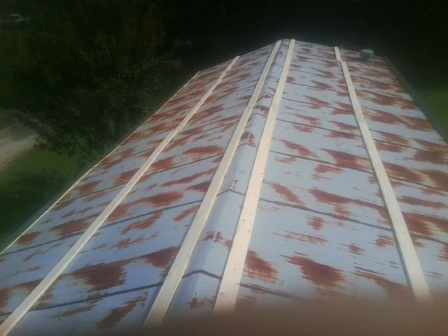 Rusted metal roof panels with new wood purlins before replacement — Storm Damage Roof Repair in Bovey by Roofing Brothers
