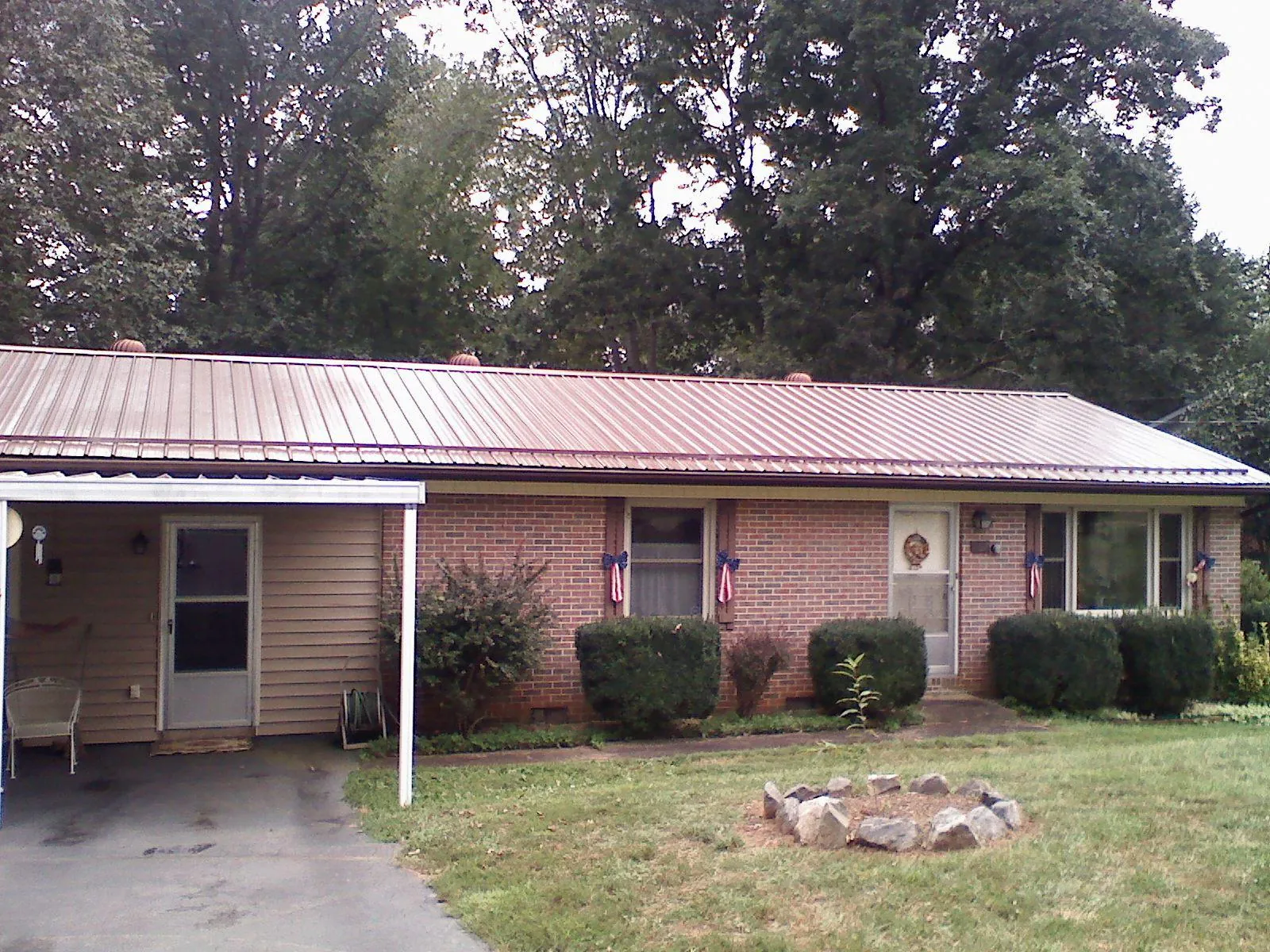 Bronze metal roof and carport on a brick ranch home — Roof Repair work by our crew in Bovey